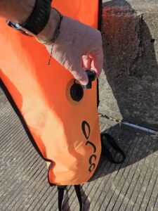 Open the deflation valve of the open water swim buoy